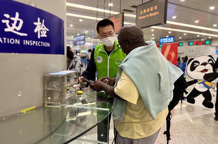 上海机场边检百人外语志愿服务队民警代表为旅客提供语言翻译。 黄波 摄